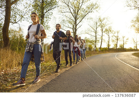 Group of friends tourists trekking with backpacks walking in the forest. Group of friends tourists trekking with backpacks walking in the forest. 137636087
