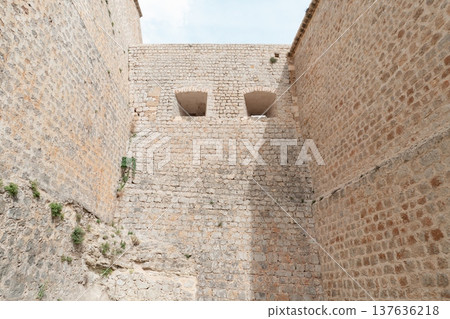 Massive stone fortress walls with embrasures in castle, Ibiza Spain Massive stone fortress walls with embrasures in castle, Ibiza Spain 137636218