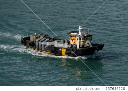 Small workboat cruising on harbor water 137636228