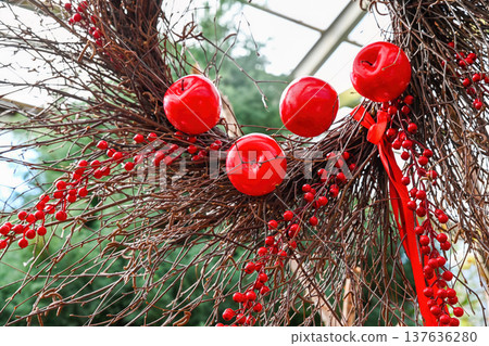 Creative autumn wreath decoration with red apple and berry on dry branch. Handmade rustic floral decor for fall season and traditional design idea. Creative autumn wreath decoration with red apple and berry on dry branch. Handmade rustic floral decor for fall season and traditional design idea. 137636280