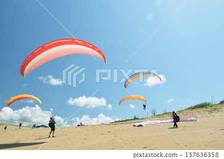 Young people enjoying paragliding in the Tottori sand dunes Young people enjoying paragliding in the Tottori sand dunes 137636358
