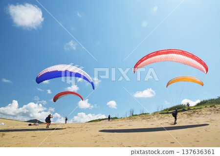 年輕人在鳥取沙丘中享受滑翔傘 137636361