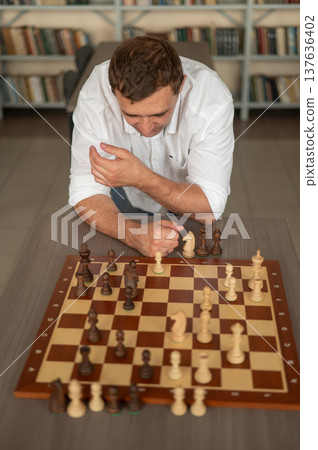 Caucasian man thinking about a chess move.  137636402