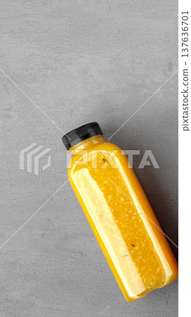Orange juice bottle on a gray surface in a bright setting in the afternoon sun Orange juice bottle on a gray surface in a bright setting in the afternoon sun 137636701