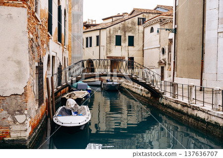Quiet canal scene with bridge and boats in Venice during the afternoon Quiet canal scene with bridge and boats in Venice during the afternoon 137636707