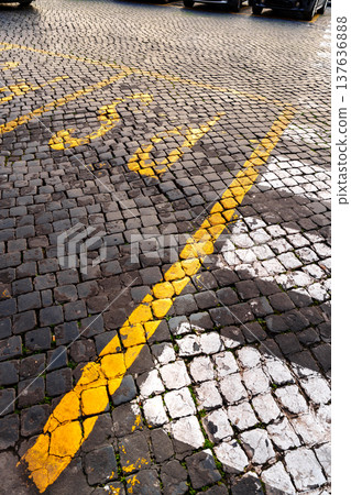 Parking lot with yellow and white lines on cobblestone surface in an urban area 137636888