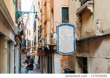 Quiet alley in Venice with a blank sign and a stone lion statue during the day Quiet alley in Venice with a blank sign and a stone lion statue during the day 137636892