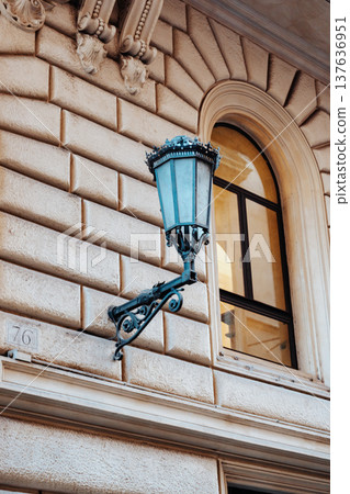 Historical building with a decorative street lamp on the wall in a city 137636951
