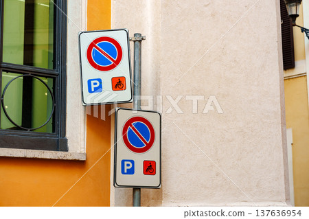 Parking signs on a street corner in a city with yellow walls during daylight hours Parking signs on a street corner in a city with yellow walls during daylight hours 137636954