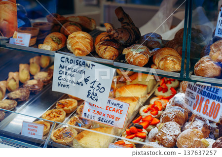 Bakery display shows a variety of pastries and desserts in a busy shop setting Bakery display shows a variety of pastries and desserts in a busy shop setting 137637257