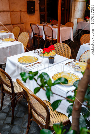 Outdoor dining setup in a restaurant with yellow plates and green plants in the evening Outdoor dining setup in a restaurant with yellow plates and green plants in the evening 137637295