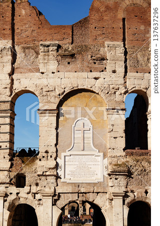 Colosseum stands tall under a clear sky in Rome during the day 137637296