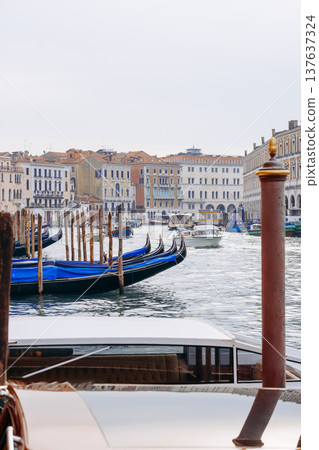 Gondolas on the water in Venice with buildings in the background during a cloudy day 137637324