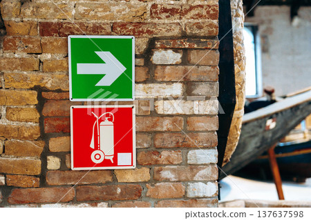 Signs showing the way and fire safety in an old building by the water Signs showing the way and fire safety in an old building by the water 137637598