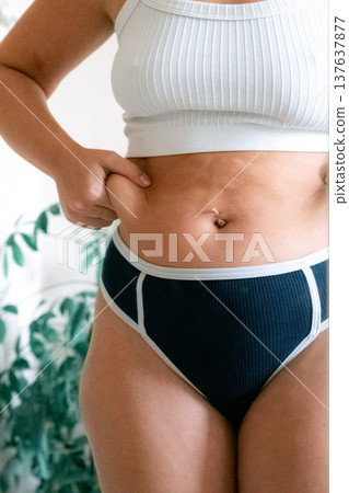 Woman overweight body. Female touching stomach near mirror. Weig 137637877