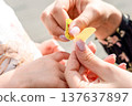 Child first aid. Toddler finger treated by parent hands. Home healthcare concept. 137637897