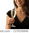 Smiling Woman Holds Champagne Flute in Black Dress on White Background 137638846