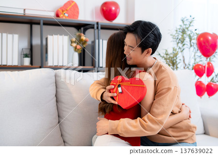 Happy asian couple embracing with love after receiving heart gift box. Happy asian couple embracing with love after receiving heart gift box. 137639022