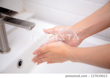 Closeup hands in sink with foaming soap, feeling hygienic and refreshed for prevention virus spread. Closeup hands in sink with foaming soap, feeling hygienic and refreshed for prevention virus spread. 137639023