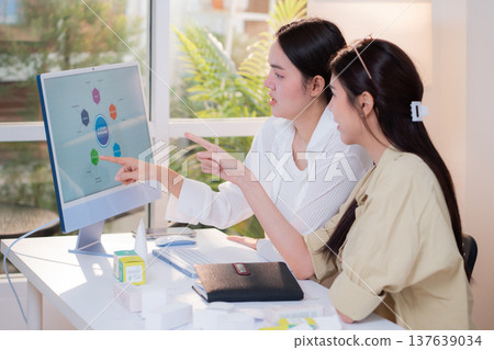 Two asian businesswoman analysis data chart graph presentation. Two asian businesswoman analysis data chart graph presentation. 137639034