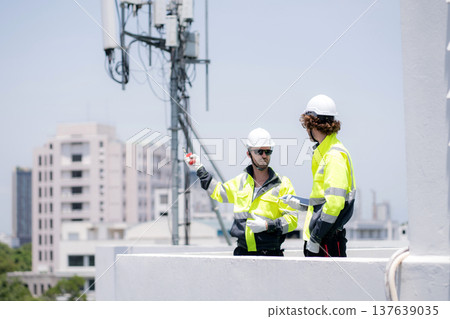 Technician team talking collaboration working on rooftop building. Technician team talking collaboration working on rooftop building. 137639035