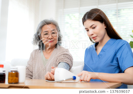 Asian woman nurse measuring blood pressure senior patient. Asian woman nurse measuring blood pressure senior patient. 137639037