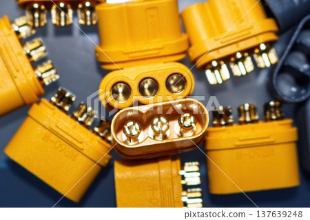 Macro shot of bright yellow MR60 power plugs, male and female, featuring gleaming gold-plated brass pins for electric motors and e-transport systems Macro shot of bright yellow MR60 power plugs, male and female, featuring gleaming gold-plated brass pins for electric motors and e-transport systems 137639248