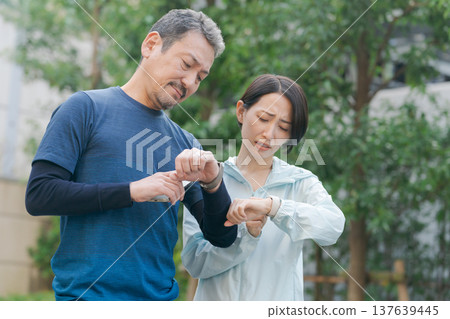 一對中年夫妻正在看手錶 137639445