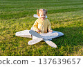 Flying girl. Yellow cardboard costume child. Park activity sunshine toddler. 137639657