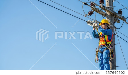 電工在電線桿上進行電力線路維護工作，檢查和維護基礎設施設備，廣告橫幅文案，背景為藍天。 137640602