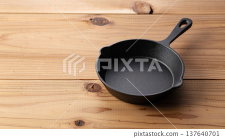 一個空的煎鍋（鑄鐵煎鍋）放在木桌上。 137640701