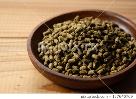 Alfalfa pellets in a wooden bowl 137640709