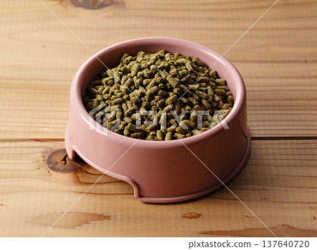 盛放在粉紅色木紋背景盤子上的兔子糧(顆粒狀) 盛放在粉紅色木紋背景盤子上的兔子糧(顆粒狀) 137640720