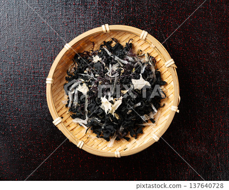 黑色背景上的竹製濾網中的乾海藻沙拉（俯視圖） 137640728