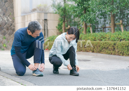 一對正在繫鞋帶的活躍夫婦 137641152