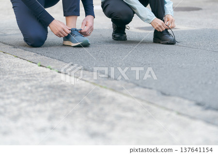 An active couple who tie their shoelaces An active couple who tie their shoelaces 137641154