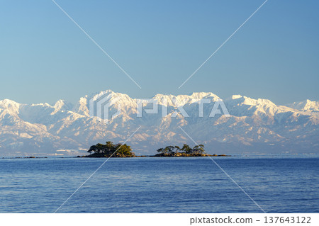 A spectacular view of Abugashima Island floating in Toyama Bay and the Tateyama mountain range. A spectacular view of Abugashima Island floating in Toyama Bay and the Tateyama mountain range. 137643122