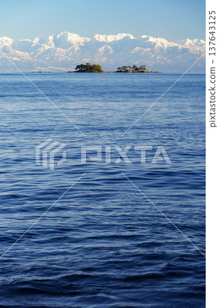A spectacular view of Abugashima Island floating in Toyama Bay and the Tateyama mountain range. A spectacular view of Abugashima Island floating in Toyama Bay and the Tateyama mountain range. 137643125