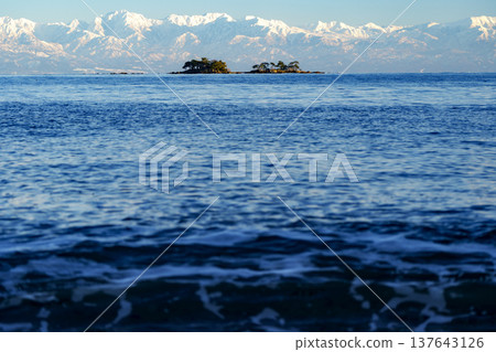 A spectacular view of Abugashima Island floating in Toyama Bay and the Tateyama mountain range. A spectacular view of Abugashima Island floating in Toyama Bay and the Tateyama mountain range. 137643126