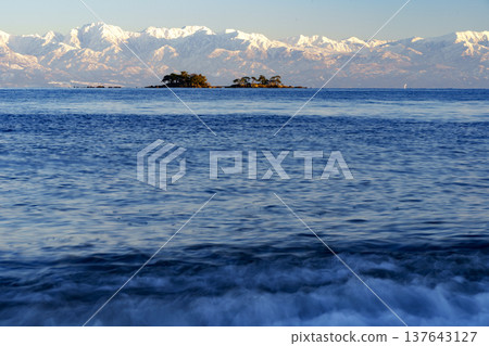 A spectacular view of Abugashima Island floating in Toyama Bay and the Tateyama mountain range. A spectacular view of Abugashima Island floating in Toyama Bay and the Tateyama mountain range. 137643127