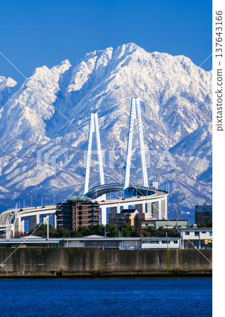 A spectacular view of the Shinminato Bridge and the Tateyama mountain range from the Nagoura Bridge. 137643166