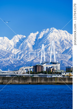 A spectacular view of the Shinminato Bridge and the Tateyama mountain range from the Nagoura Bridge. A spectacular view of the Shinminato Bridge and the Tateyama mountain range from the Nagoura Bridge. 137643170