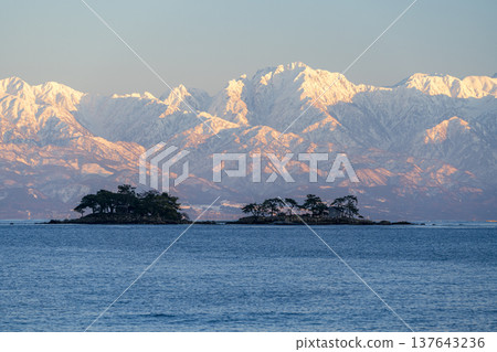 A spectacular view of Abugashima Island floating in Toyama Bay and the Tateyama mountain range. A spectacular view of Abugashima Island floating in Toyama Bay and the Tateyama mountain range. 137643236