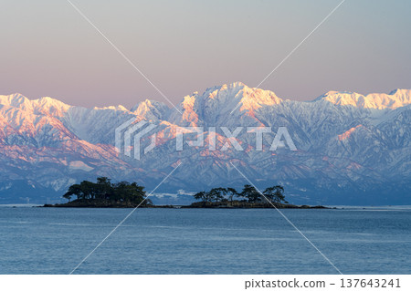 A spectacular view of Abugashima Island floating in Toyama Bay and the Tateyama mountain range. A spectacular view of Abugashima Island floating in Toyama Bay and the Tateyama mountain range. 137643241