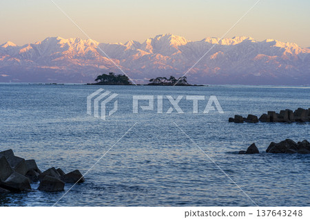 A spectacular view of Abugashima Island floating in Toyama Bay and the Tateyama mountain range. 137643248