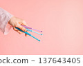 Hand holding three single tuft toothbrushes on pink background, dental hygiene concept with copy space 137643405