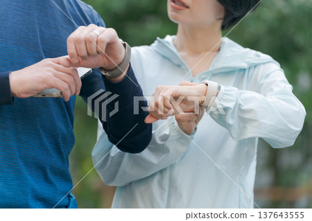 運動時,男男女女都在看手錶。 運動時,男男女女都在看手錶。 137643555