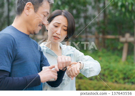 運動時,男男女女都在看手錶。 運動時,男男女女都在看手錶。 137643556