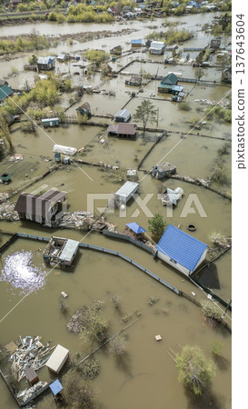 Spring flood disaster with fully submerged houses, flooded roads and overflowing waterways. The footage shows the dramatic impact of heavy rainfall and rising water levels on residential areas 137643604
