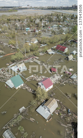 Spring flood disaster with fully submerged houses, flooded roads and overflowing waterways. The footage shows the dramatic impact of heavy rainfall and rising water levels on residential areas 137643606